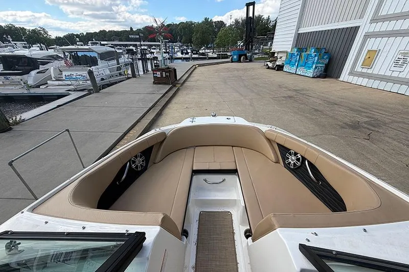 Slide: The Image of 2021 Sea Ray SPX 210 boat interior at marina dock, featuring tan seating and modern design. - 22