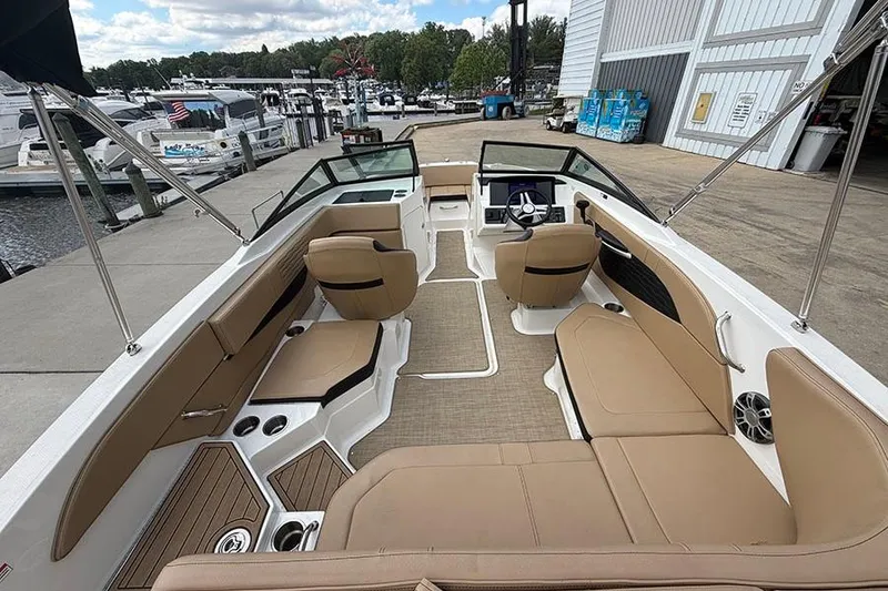 Slide: The Image of 2021 Sea Ray SPX 210 boat interior with tan seating, docked at a marina. - 7