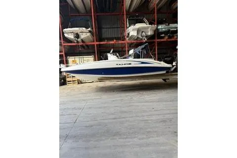 The Image of 2020 Tahoe 2150 CC boat in storage, featuring a sleek blue and white design. - 0