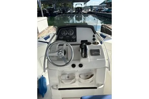 Slide: The Image of 2020 Tahoe 2150 CC boat dashboard with steering wheel and controls at marina. - 7