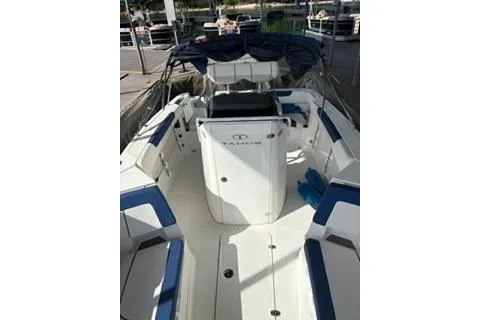 Slide: The Image of 2020 Tahoe 2150 CC boat with blue and white seating, docked at marina. - 8