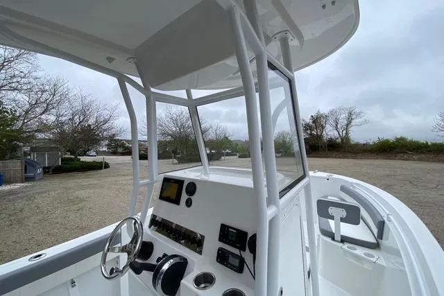 Slide: The Image of 2021 Release 210 RX boat console with steering wheel and navigation controls, parked outdoors. - 12