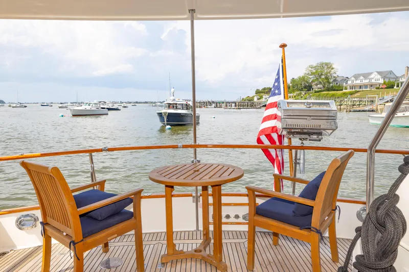 Slide: The Image of Deck view of 2002 Grand Banks 46 Europa yacht with chairs, table, and American flag. - 28
