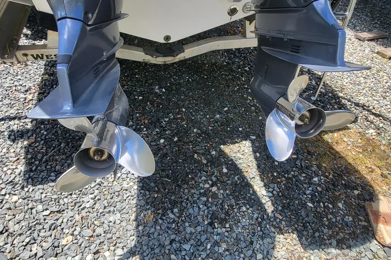 Slide: The Image of Twin propellers of a 2020 Sportsman Open 282 Center Console on gravel. - 17