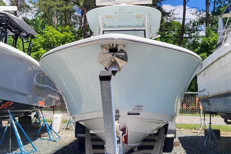 Slide: The Image of 2020 Sportsman Open 282 Center Console boat on trailer, surrounded by trees and other boats. - 4