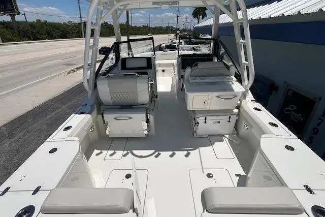 Slide: The Image of 2026 World Cat 265 DC-X boat interior with seating and helm, docked outdoors. - 8