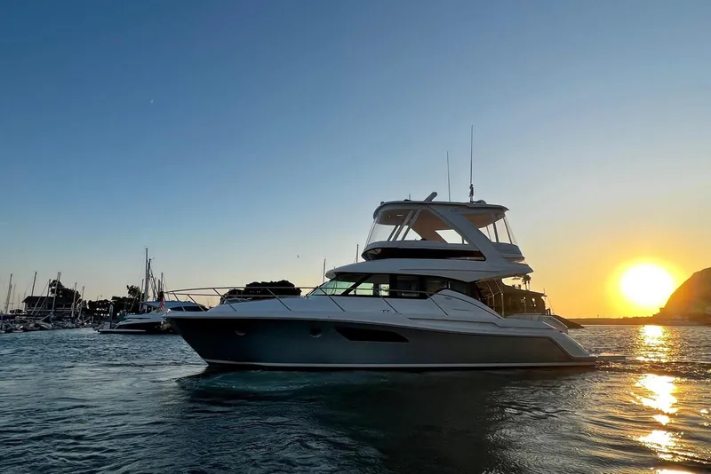 Slide: The Image of 2019 Tiara Yachts F44 Flybridge at sunset in marina. - 11