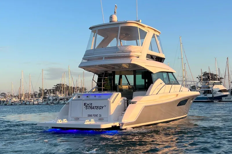Slide: The Image of 2019 Tiara Yachts F44 Flybridge in marina, illuminated at sunset. - 17