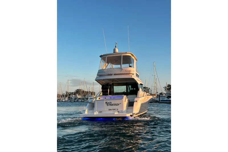 Slide: The Image of 2019 Tiara Yachts F44 Flybridge cruising in marina at sunset. - 18