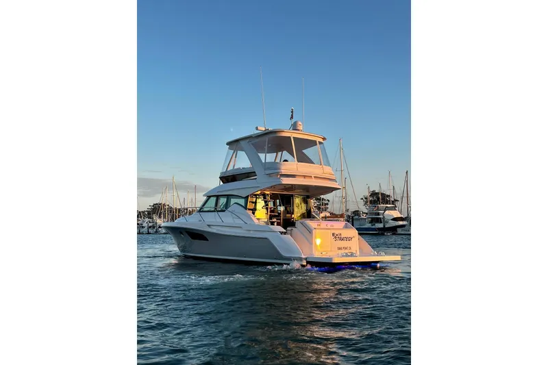 Slide: The Image of 2019 Tiara Yachts F44 Flybridge cruising in a marina at sunset. - 20