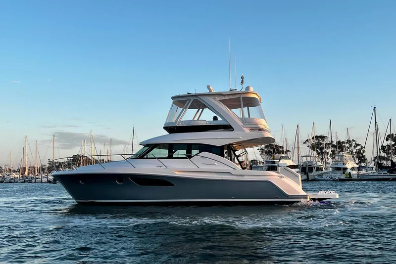 Slide: The Image of 2019 Tiara Yachts F44 Flybridge cruising in a marina at sunset. - 22