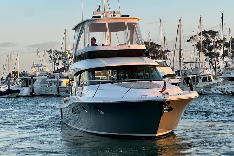 Slide: The Image of 2019 Tiara Yachts F44 Flybridge cruising in a marina at sunset. - 23