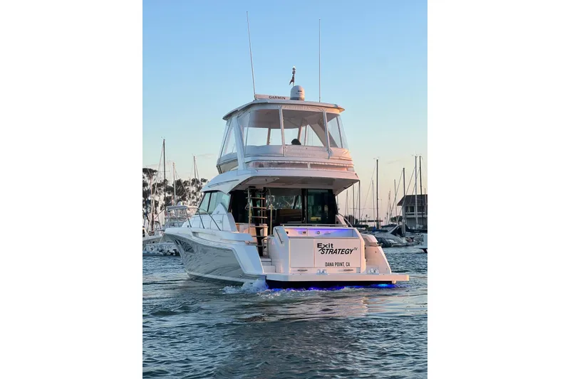 Slide: The Image of 2019 Tiara Yachts F44 Flybridge cruising in a marina at sunset. - 27