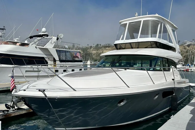 Slide: The Image of 2019 Tiara Yachts F44 Flybridge docked in marina, showcasing sleek design and spacious flybridge. - 31