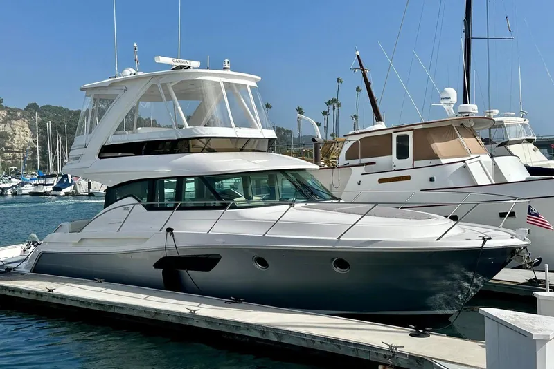 Slide: The Image of 2019 Tiara Yachts F44 Flybridge docked at a marina under clear skies. - 32