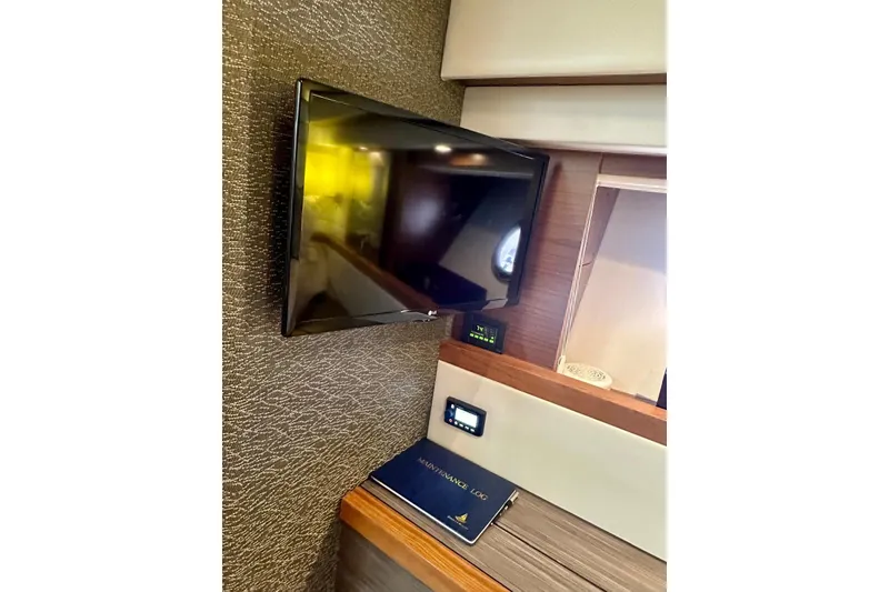 Slide: The Image of Flat-screen TV and control panel in 2019 Tiara Yachts F44 Flybridge interior. - 33