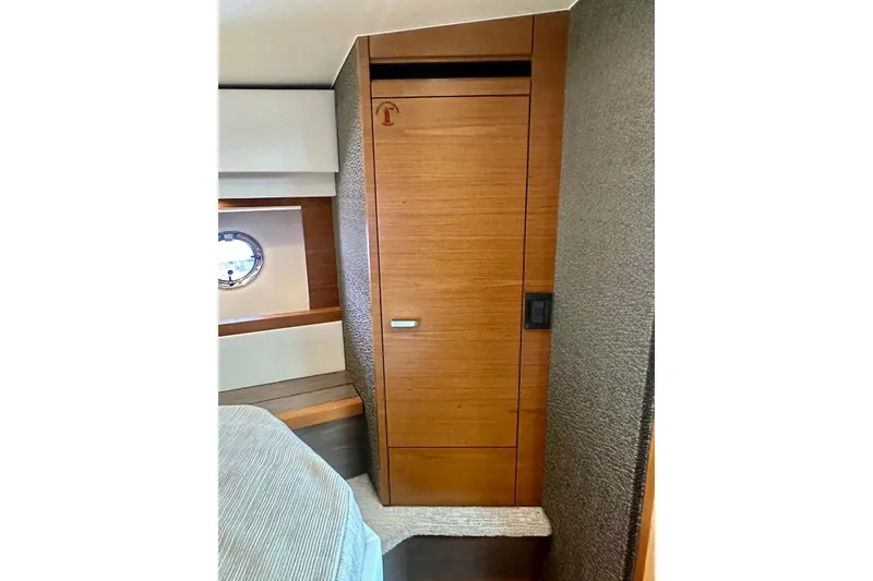 Slide: The Image of 2019 Tiara Yachts F44 Flybridge interior with wooden cabinetry and porthole window. - 34