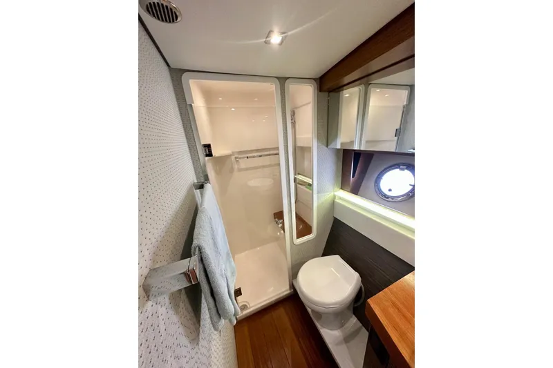 Slide: The Image of Luxurious bathroom in 2019 Tiara Yachts F44 Flybridge with modern fixtures and porthole window. - 43