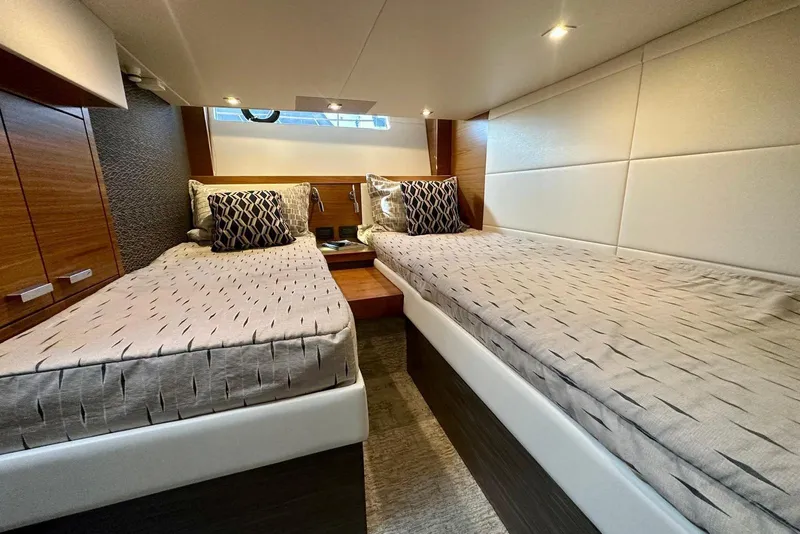 Slide: The Image of Luxurious twin cabin interior of 2019 Tiara Yachts F44 Flybridge, featuring elegant bedding and lighting. - 47