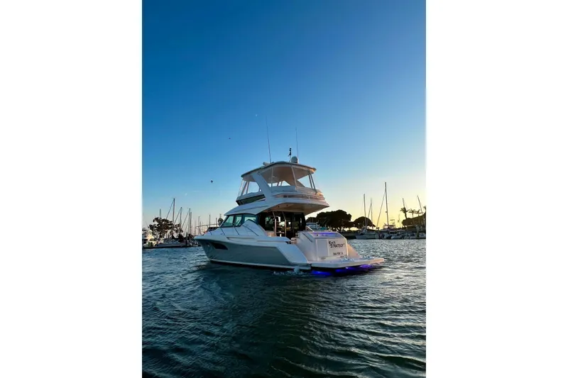 Slide: The Image of 2019 Tiara Yachts F44 Flybridge cruising at sunset in a marina. - 5