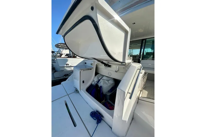Slide: The Image of 2019 Tiara Yachts F44 Flybridge storage compartment open, showcasing interior space and equipment. - 55