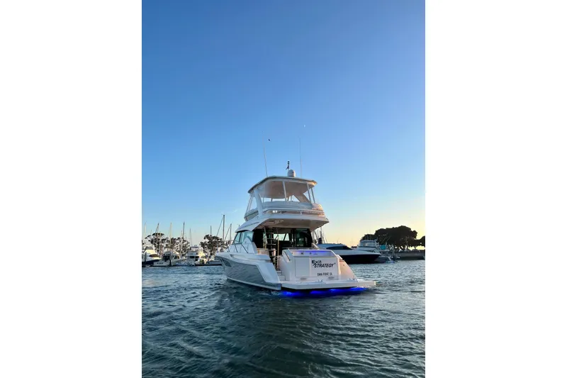 Slide: The Image of 2019 Tiara Yachts F44 Flybridge on water at sunset, marina background. - 6