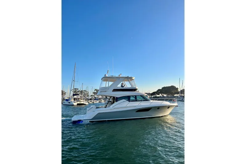 Slide: The Image of 2019 Tiara Yachts F44 Flybridge cruising in a marina under clear blue skies. - 64