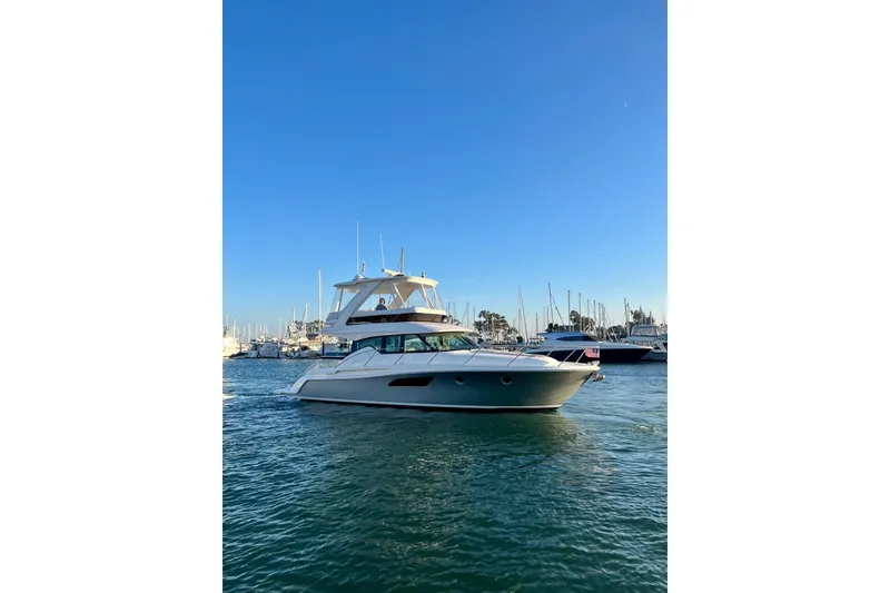 Slide: The Image of 2019 Tiara Yachts F44 Flybridge cruising in a marina under clear blue skies. - 66