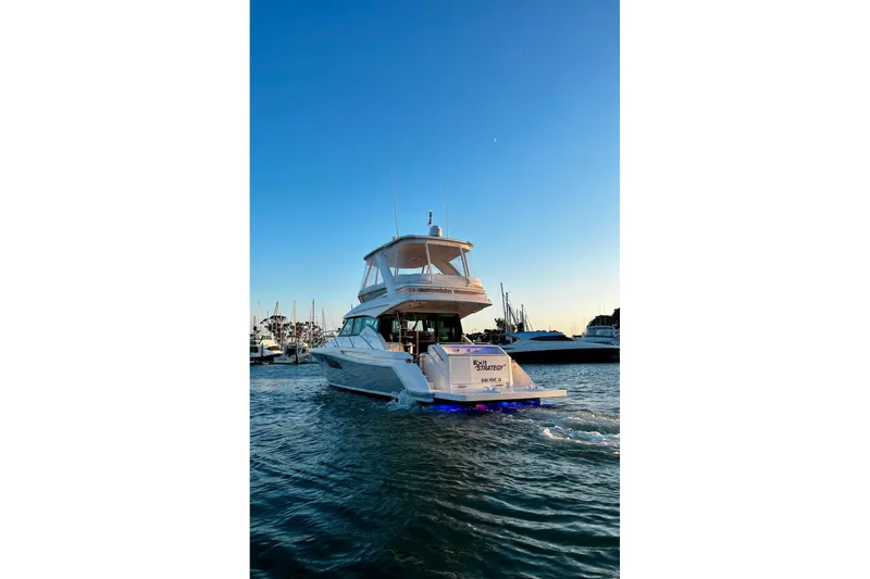 Slide: The Image of 2019 Tiara Yachts F44 Flybridge cruising at sunset in a marina. - 7