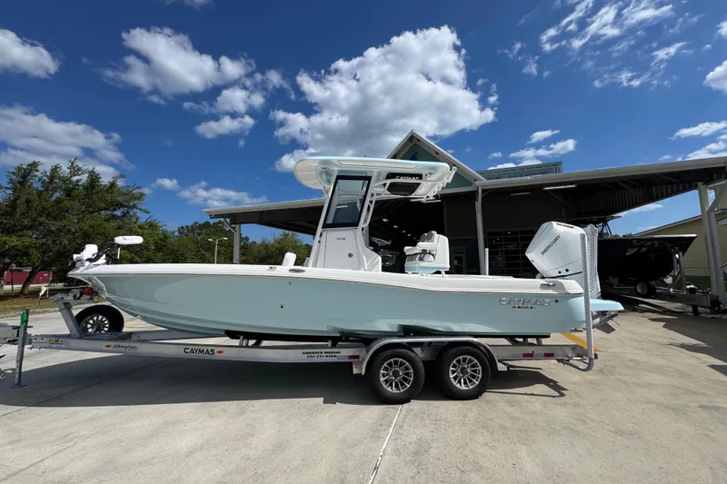 The Image of 2026 Caymas 26 HB boat on trailer under blue sky with clouds. - 1