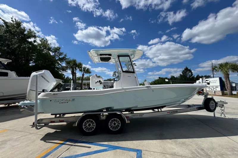 Slide: The Image of 2026 Caymas 26 HB boat on trailer under a clear blue sky. - 10