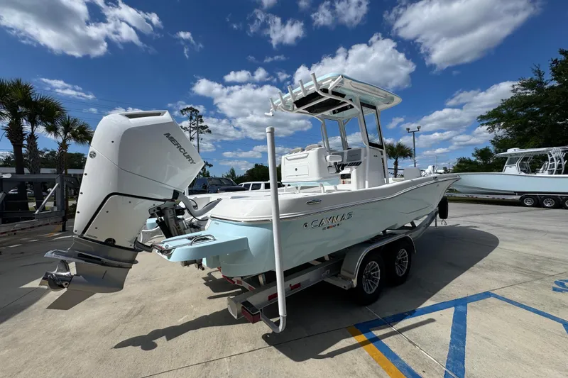 Slide: The Image of 2026 Caymas 26 HB boat with Mercury engine on trailer under blue sky. - 11