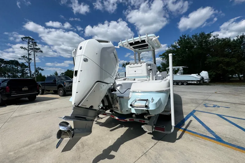 Slide: The Image of 2026 Caymas 26 HB boat with powerful outboard motor in a sunny parking lot. - 12
