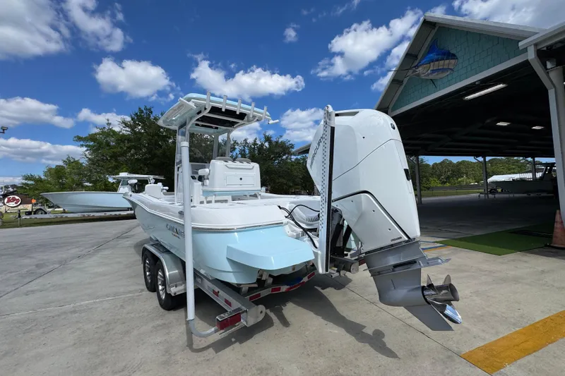 Slide: The Image of 2026 Caymas 26 HB boat on trailer, parked outdoors under a clear blue sky. - 14