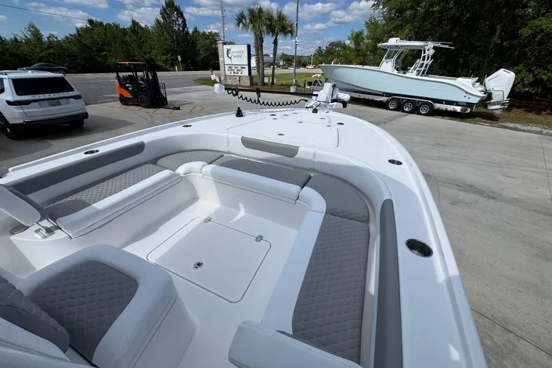 Slide: The Image of 2026 Caymas 26 HB boat with spacious seating, parked outdoors under a clear sky. - 16