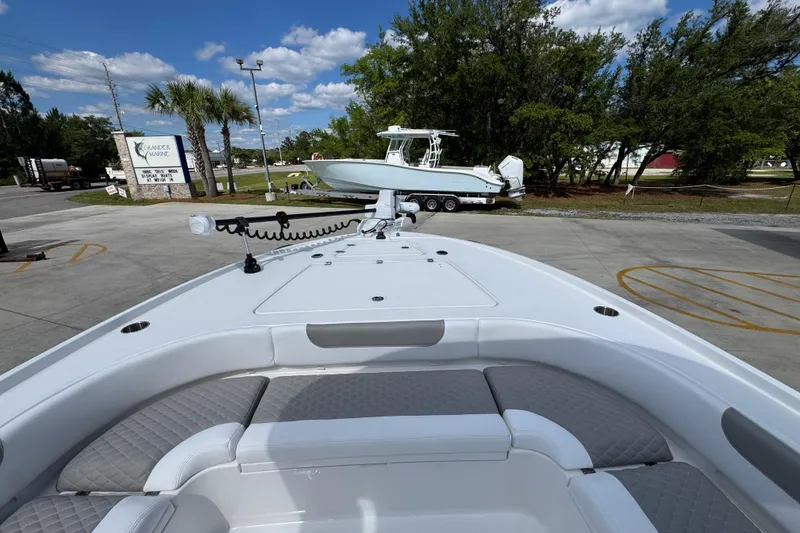 Slide: The Image of 2026 Caymas 26 HB boat with spacious seating, parked outdoors under a clear sky. - 17