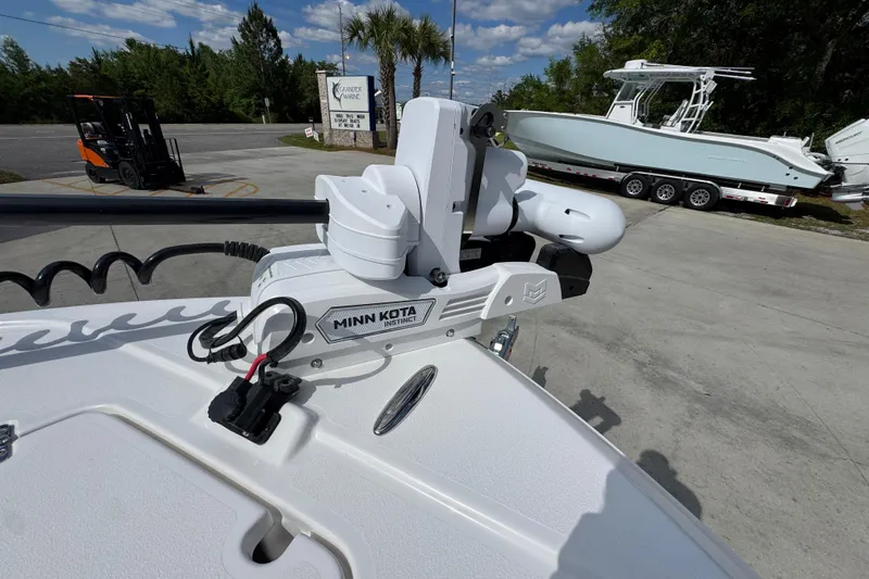Slide: The Image of Minn Kota Instinct motor on 2026 Caymas 26 HB boat, parked outdoors. - 19
