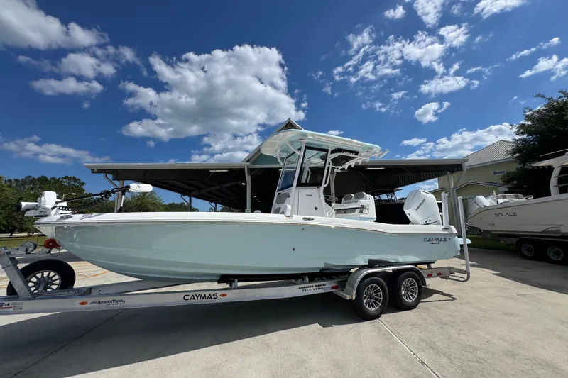 Slide: The Image of 2026 Caymas 26 HB boat on trailer under clear blue sky. - 2