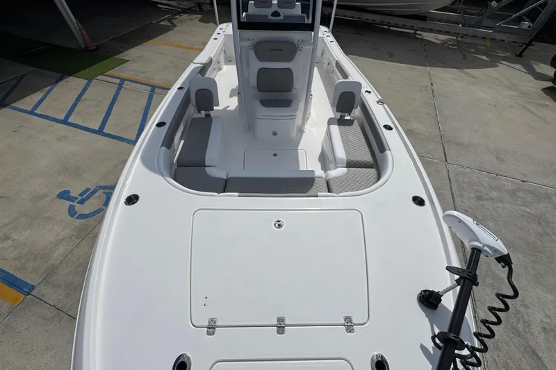 Slide: The Image of 2026 Caymas 26 HB boat interior with seating and deck, parked on concrete. - 20