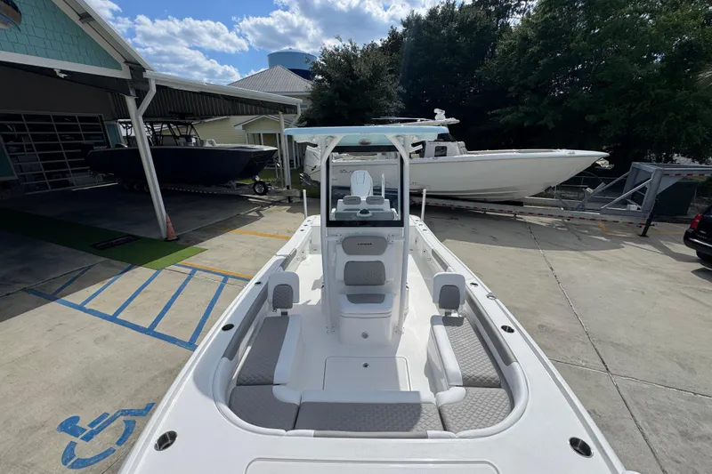 Slide: The Image of 2026 Caymas 26 HB boat displayed outdoors at a dealership. - 21