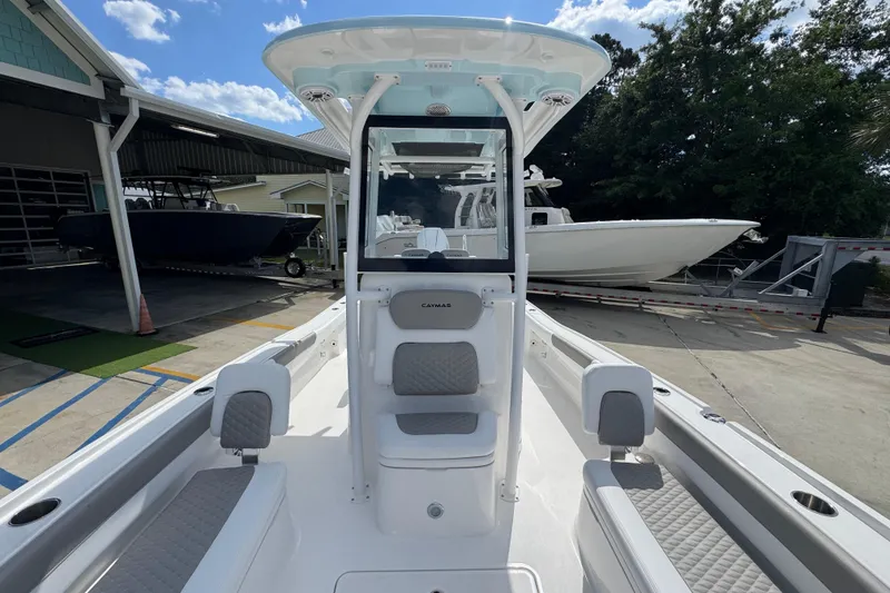 Slide: The Image of 2026 Caymas 26 HB boat with sleek design, docked outdoors under a clear sky. - 22