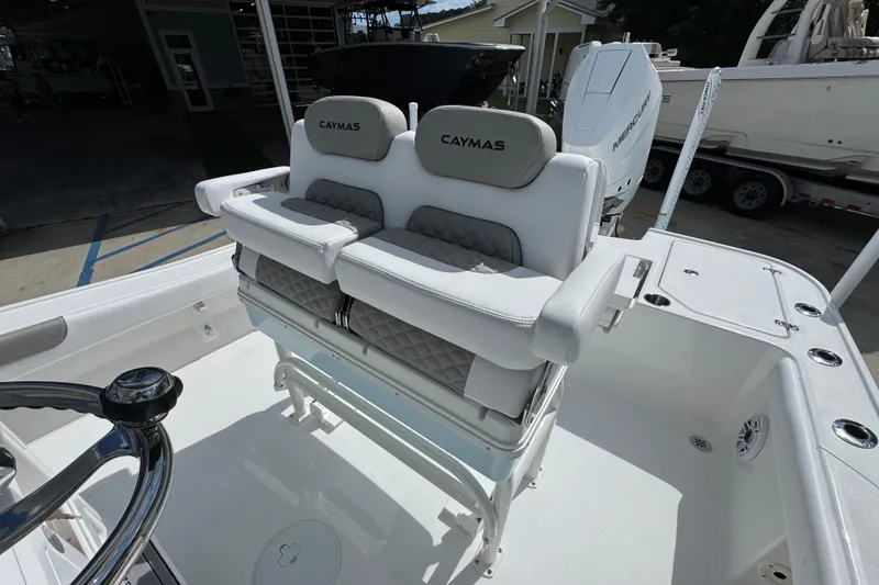 Slide: The Image of 2026 Caymas 26 HB boat interior with cushioned seating and steering wheel. - 26