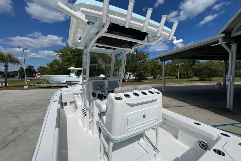 Slide: The Image of 2026 Caymas 26 HB boat with center console, rod holders, and Garmin electronics under a blue sky. - 32