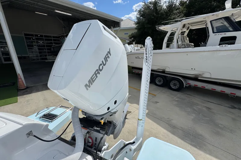Slide: The Image of 2026 Caymas 26 HB boat with Mercury engine and Power-Pole, parked outdoors. - 35