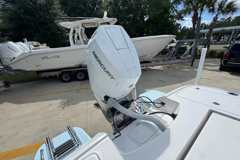 Slide: The Image of 2026 Caymas 26 HB boat with Mercury engine, parked near a Solace boat on a trailer. - 36