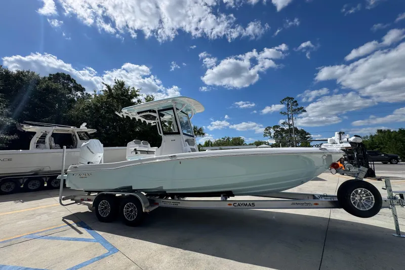 Slide: The Image of 2026 Caymas 26 HB boat on trailer under blue sky with clouds. - 9