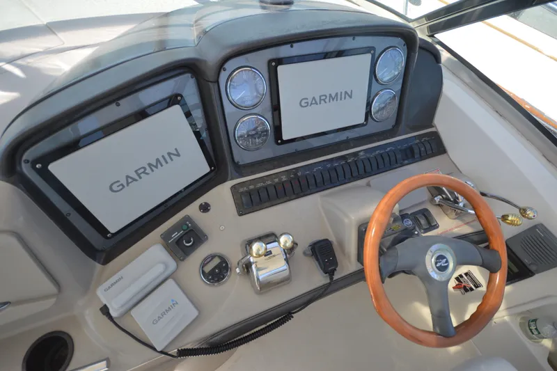 Slide: The Image of 2006 Sea Ray 40 Sundancer helm with Garmin navigation displays and wooden steering wheel. - 11