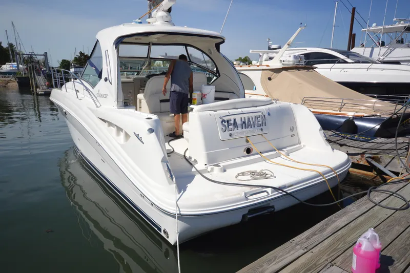 Slide: The Image of 2006 Sea Ray 40 Sundancer yacht docked, featuring "Sea Haven" nameplate, with person onboard. - 2