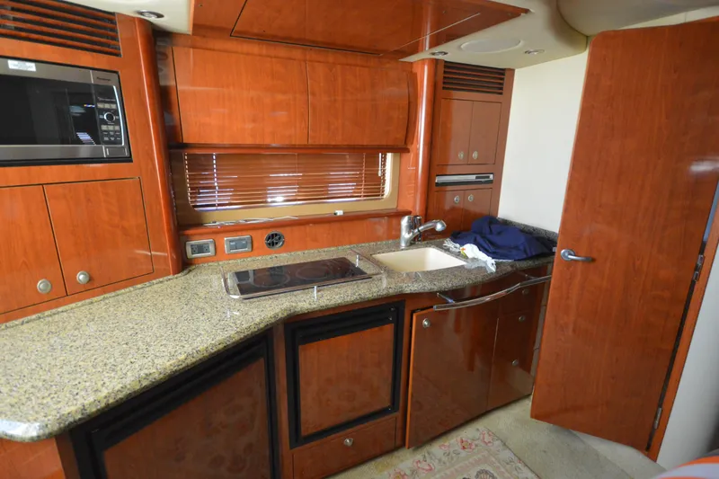 Slide: The Image of Luxurious 2006 Sea Ray 40 Sundancer yacht kitchen with wood cabinetry and granite countertops. - 25