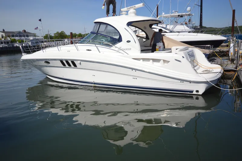 Slide: The Image of 2006 Sea Ray 40 Sundancer yacht docked in a marina, reflecting on calm water. - 4